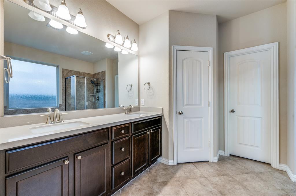 16008 Aquilla Way Prosper, TX 75078 - Photo 16 of 33 a spacious bathroom with a double vanity sink a large mirror and a shower