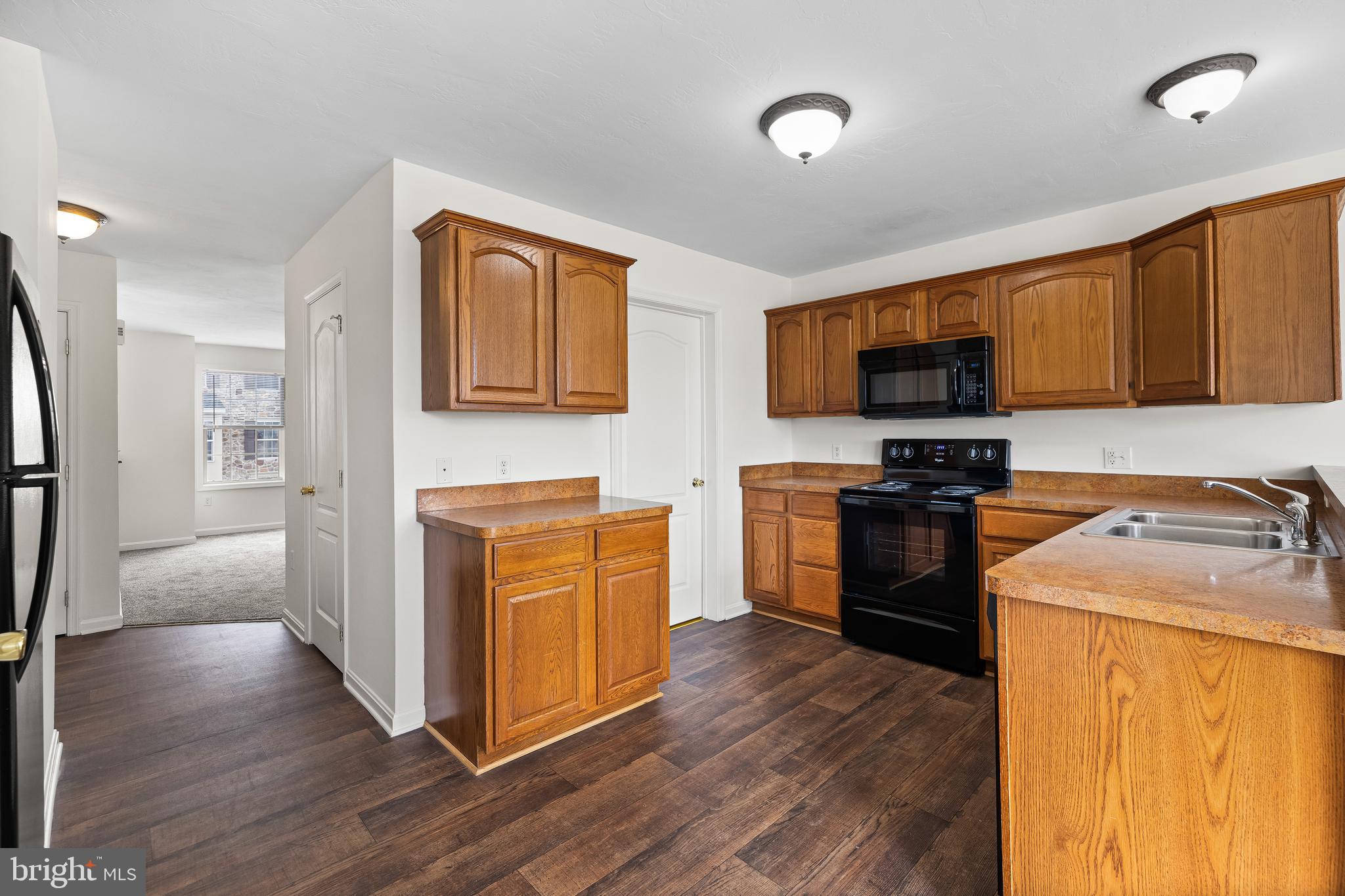10 Shady Tree Court York, PA 17402 - Photo 8 of 30 a kitchen with stainless steel appliances granite countertop a stove top oven a sink dishwasher a refrigerator and a microwave oven with wooden floor