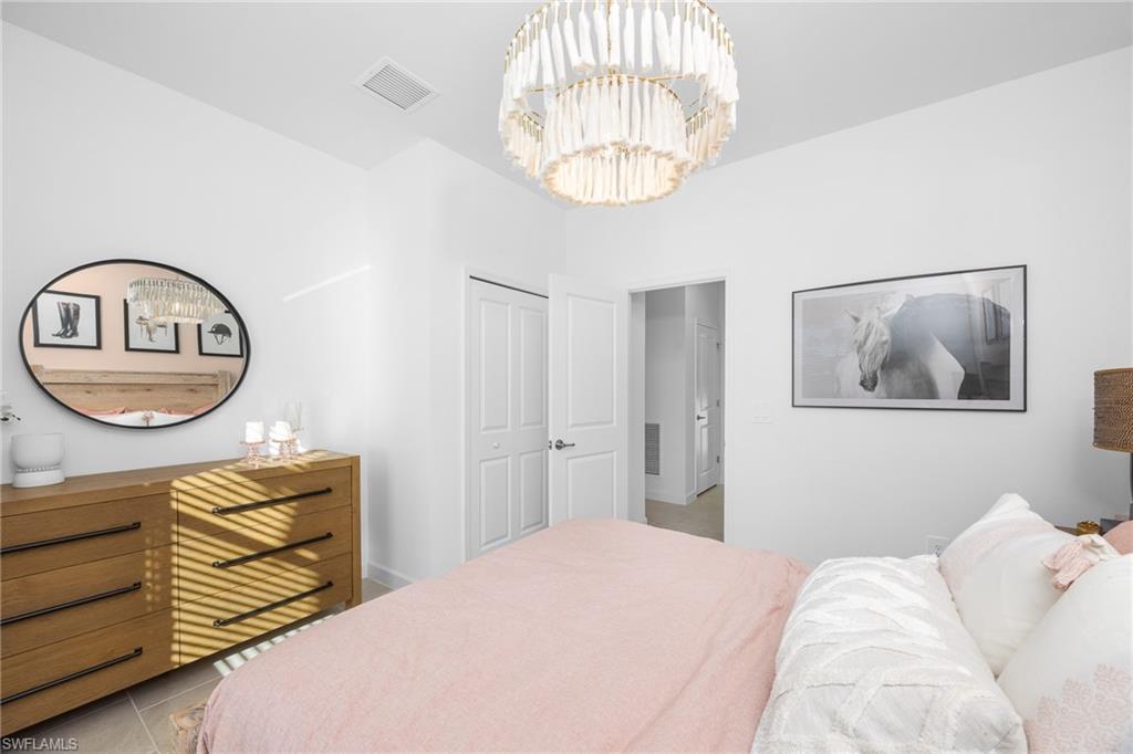 17752 Saddleback Loop North Fort Myers, FL 33917 - Photo 28 of 37 Tiled bedroom with a chandelier and a closet