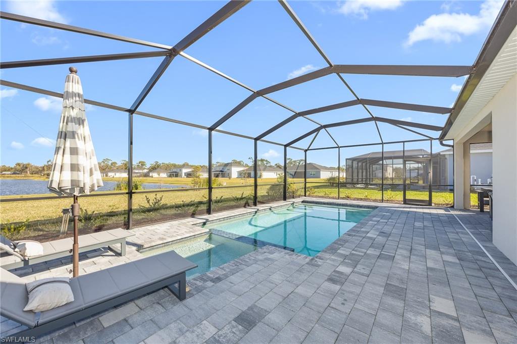 17752 Saddleback Loop North Fort Myers, FL 33917 - Photo 3 of 37 View of pool featuring a patio, a water view, a residential view, a pool with connected hot tub, and a lawn