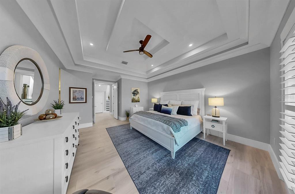 701 Pinckney Drive Apollo Beach, FL 33572 - Photo 28 of 99 a spacious bedroom with a large bed and a chandelier