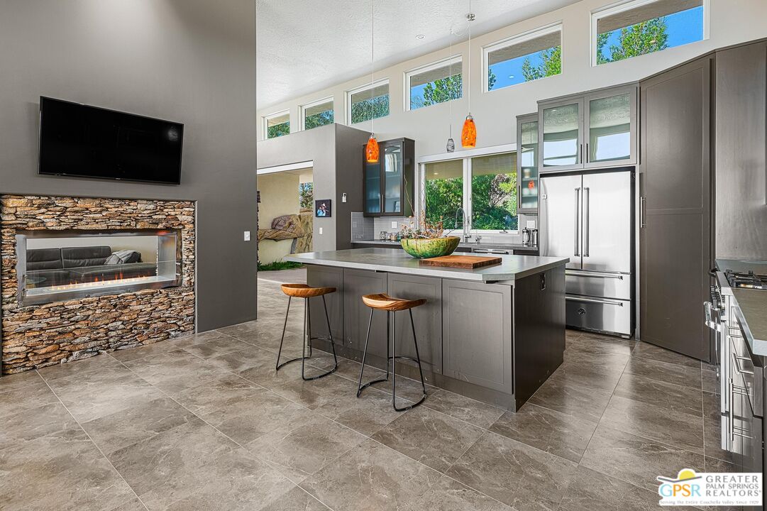 4974 Avenida Del Sol Joshua Tree, CA 92252 - Photo 14 of 36 a kitchen with stainless steel appliances a stove a refrigerator and a fireplace