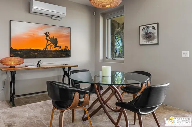a dining room with furniture and a large window