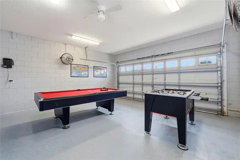 a room with pool table and windows