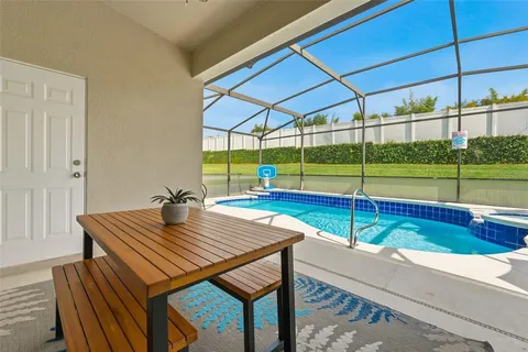 a view of a swimming pool with a table and chairs under an umbrella