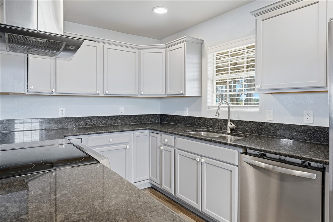 131 Janecek Road Rockport, TX 78382 - Photo 16 of 38 a kitchen with granite countertop a sink stainless steel appliances white cabinets and a window