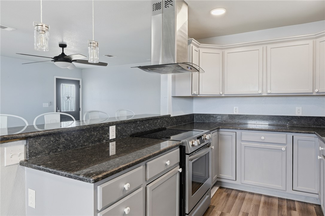 131 Janecek Road Rockport, TX 78382 - Photo 17 of 38 a kitchen with granite countertop a sink a stove and cabinets