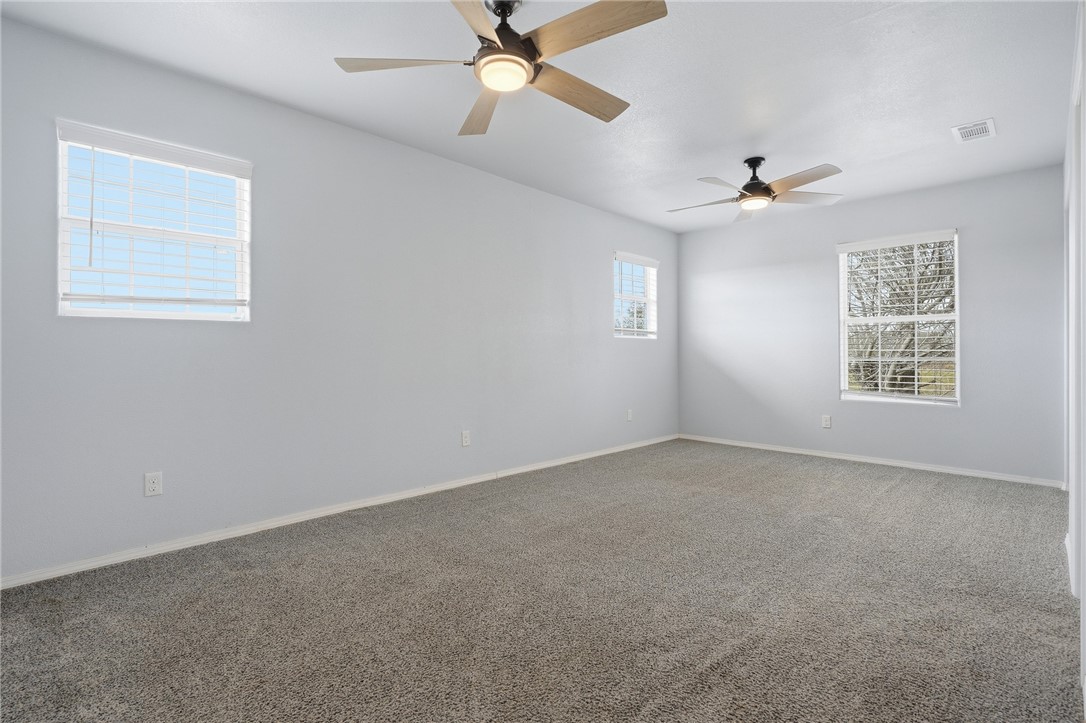 131 Janecek Road Rockport, TX 78382 - Photo 19 of 38 en empty room with windows and ceiling fan