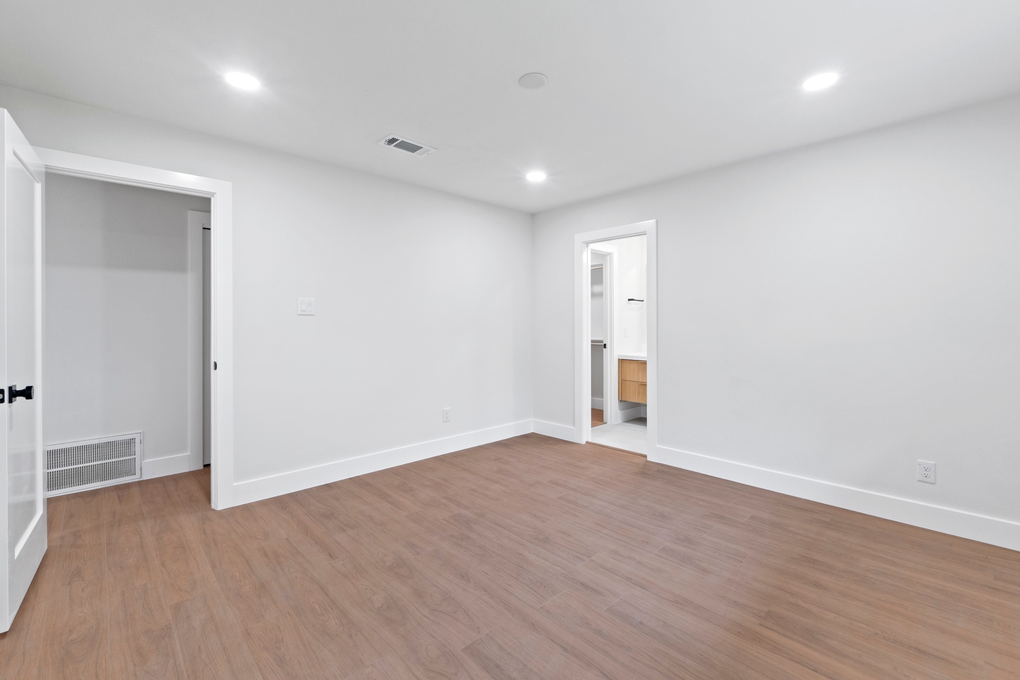 1608 Springer Lane Austin, TX 78758 - Photo 29 of 35 Spacious room featuring wood-finish flooring, white walls, recessed lighting, and crisp white baseboards