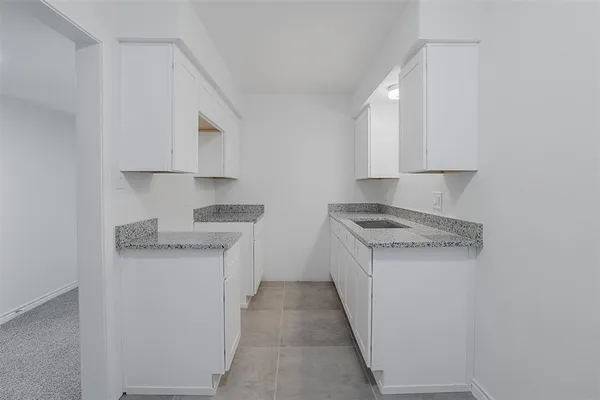 a kitchen with granite countertop cabinets sink and stove