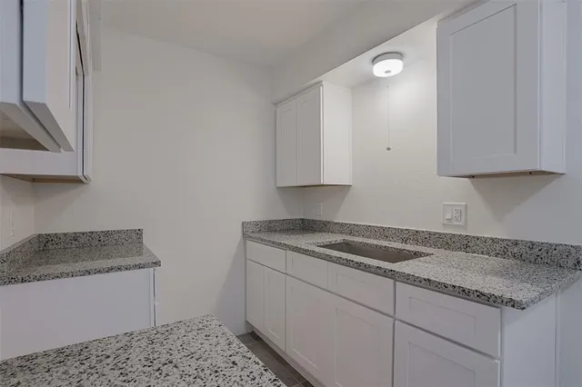 a kitchen with granite countertop a sink stainless steel appliances and cabinets