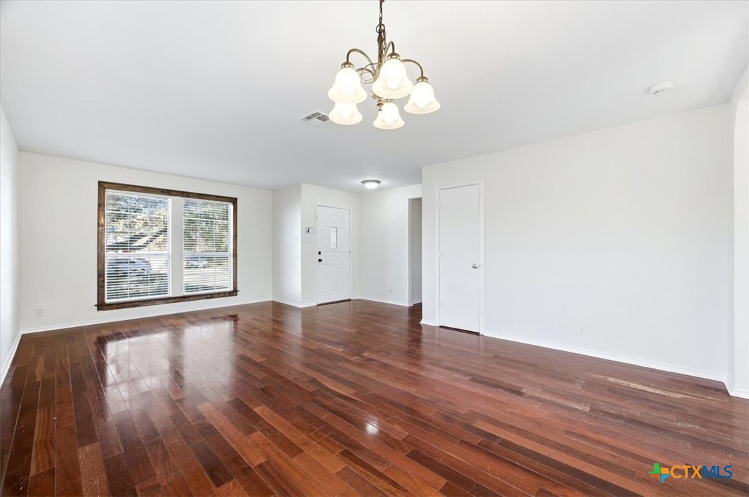 2030 Castleberry Ridge New Braunfels, TX 78130 - Photo 11 of 43 a view of an empty room with wooden floor and a window