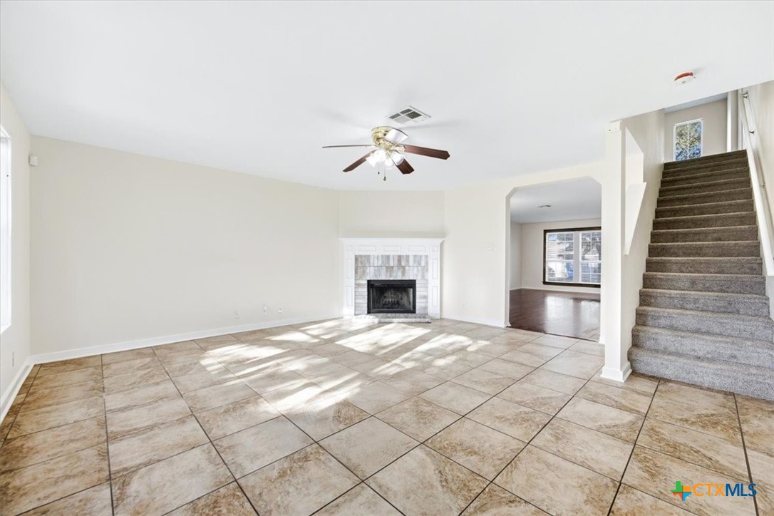 2030 Castleberry Ridge New Braunfels, TX 78130 - Photo 13 of 43 a view of an empty room with a fireplace and a chandelier
