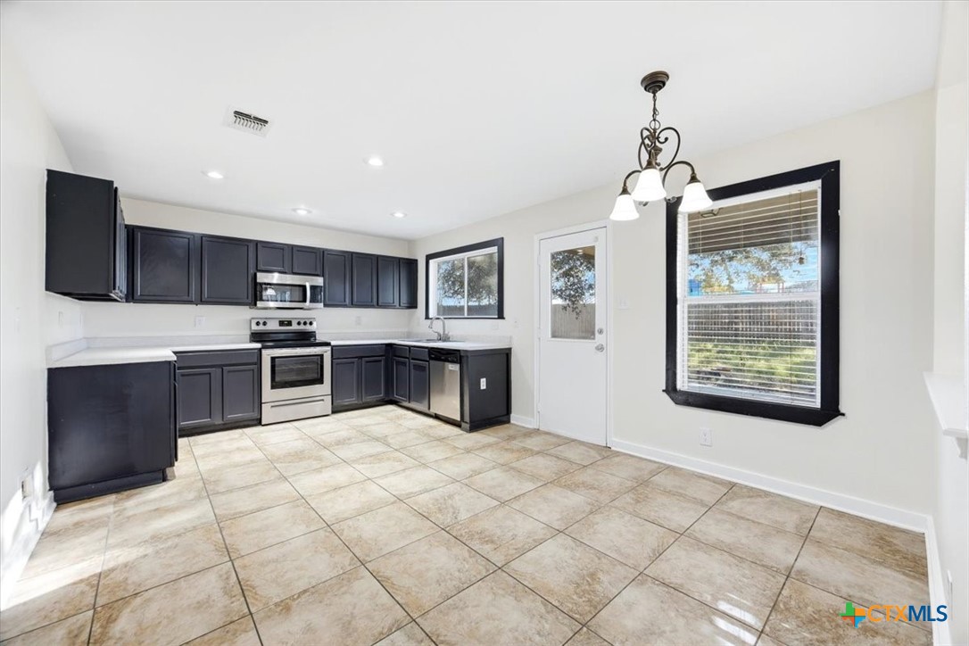 2030 Castleberry Ridge New Braunfels, TX 78130 - Photo 15 of 43 a kitchen with stainless steel appliances kitchen island granite countertop a sink and cabinets