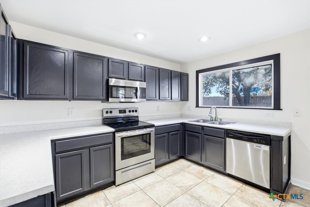 2030 Castleberry Ridge New Braunfels, TX 78130 - Photo 19 of 43 a kitchen with stainless steel appliances granite countertop a stove sink and cabinets