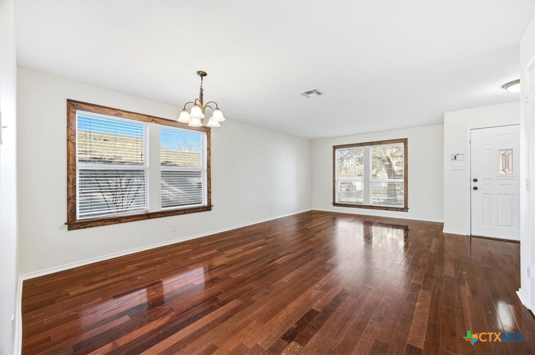 2030 Castleberry Ridge New Braunfels, TX 78130 - Photo 10 of 43 a view of an empty room with wooden floor and a window
