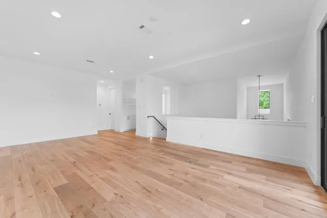 a view of empty room with wooden floor and window