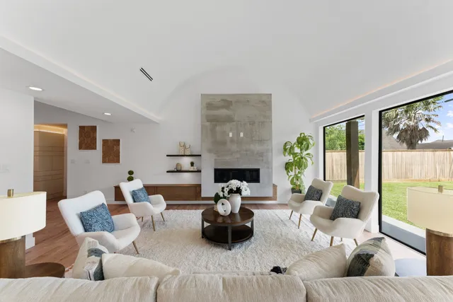 a living room with furniture fireplace and a large window