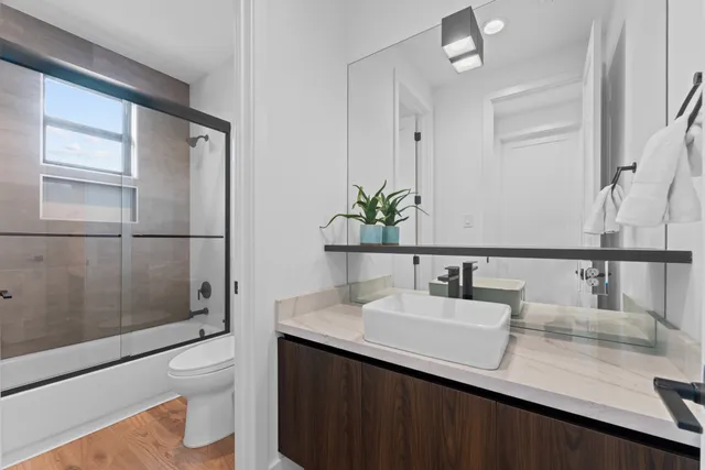 a bathroom with a sink a toilet and shower