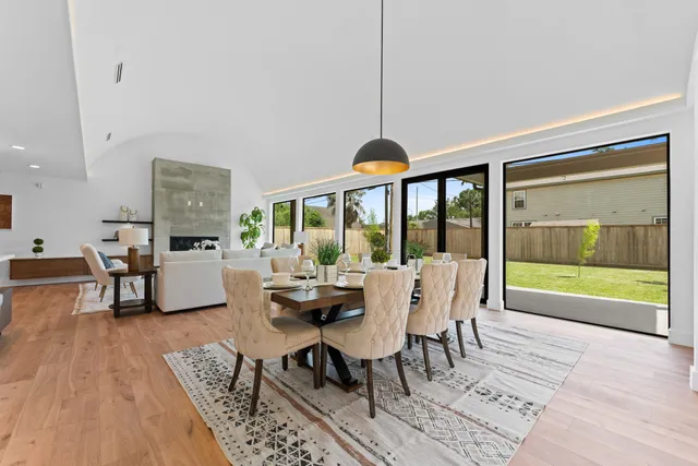 a dining room with furniture a chandelier and wooden floor