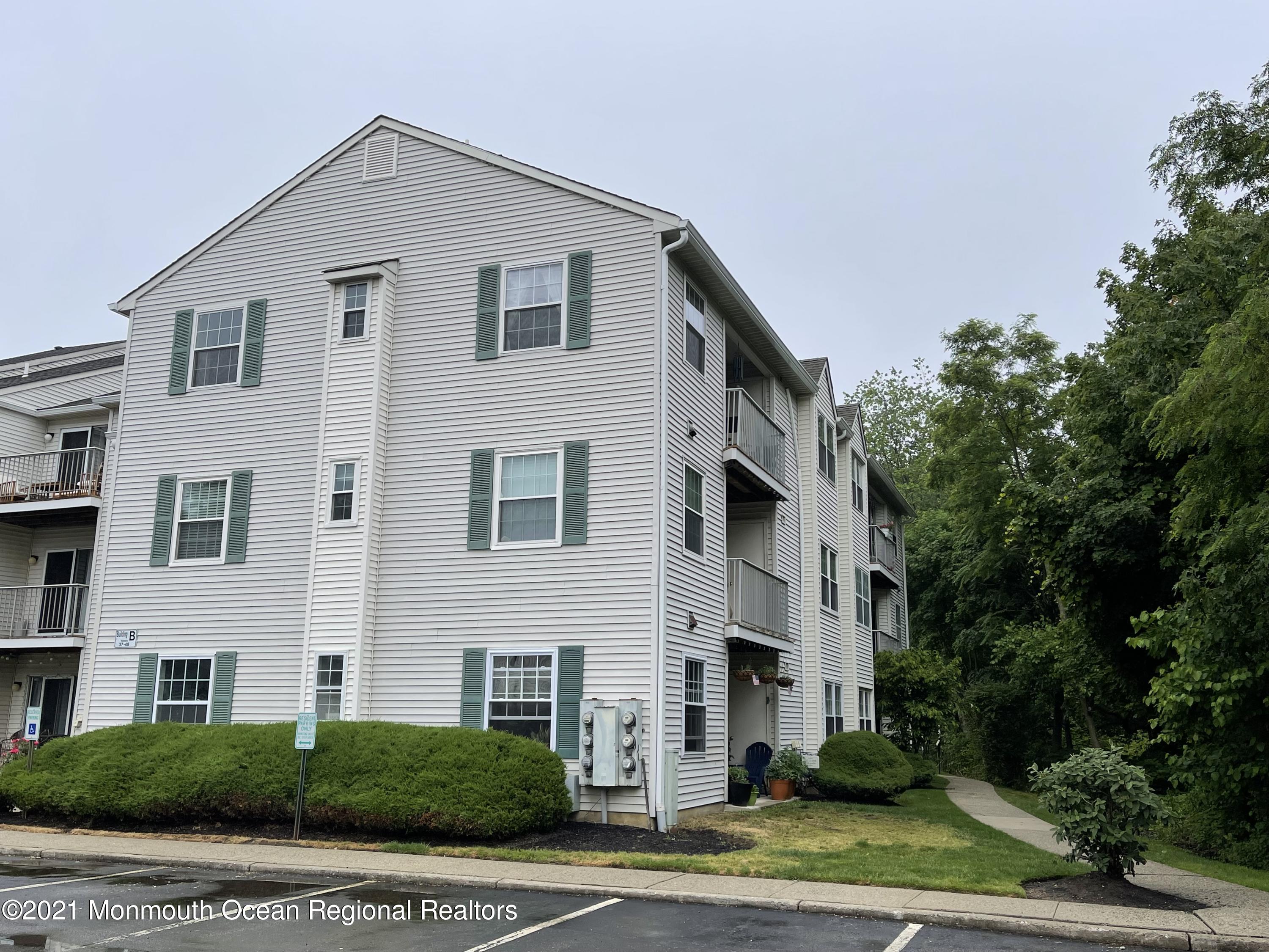 a view of a white house with a yard and large windows