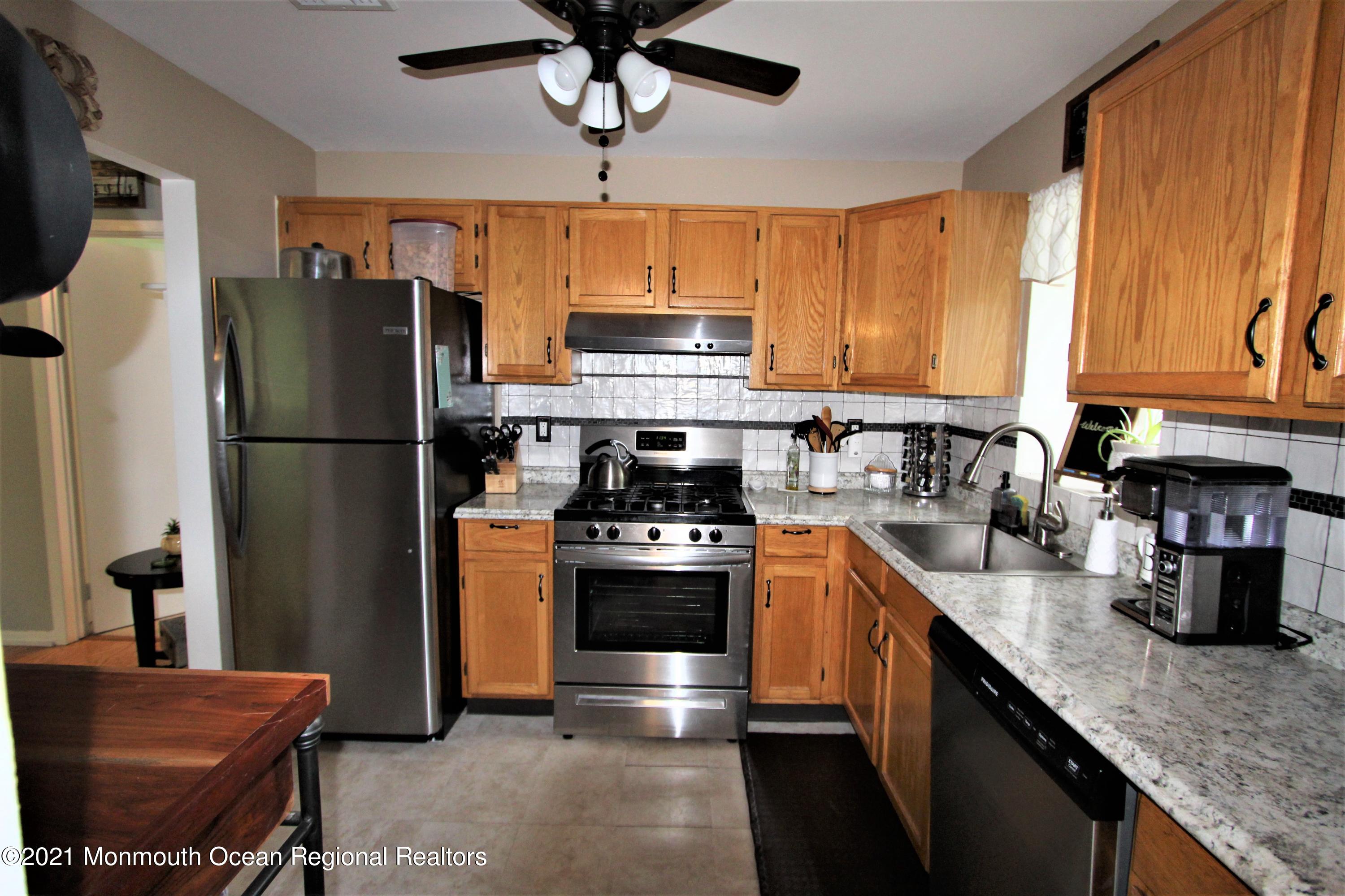 231 Atlantic Street, Unit 48 Keyport, NJ 07735 - Photo 16 of 32 a kitchen with stainless steel appliances granite countertop a stove refrigerator sink and cabinets