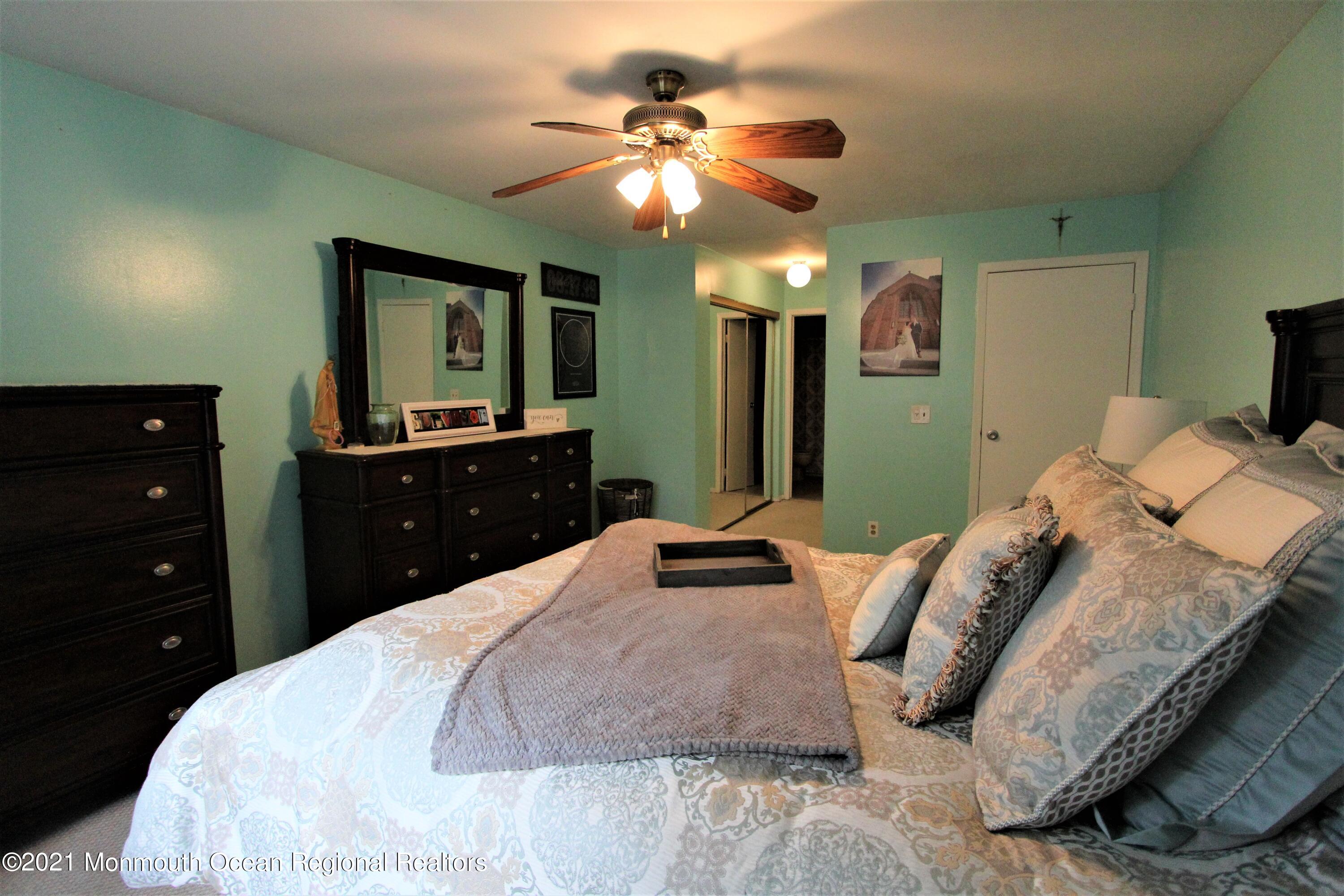 231 Atlantic Street, Unit 48 Keyport, NJ 07735 - Photo 20 of 32 a bedroom with a bed and a chandelier