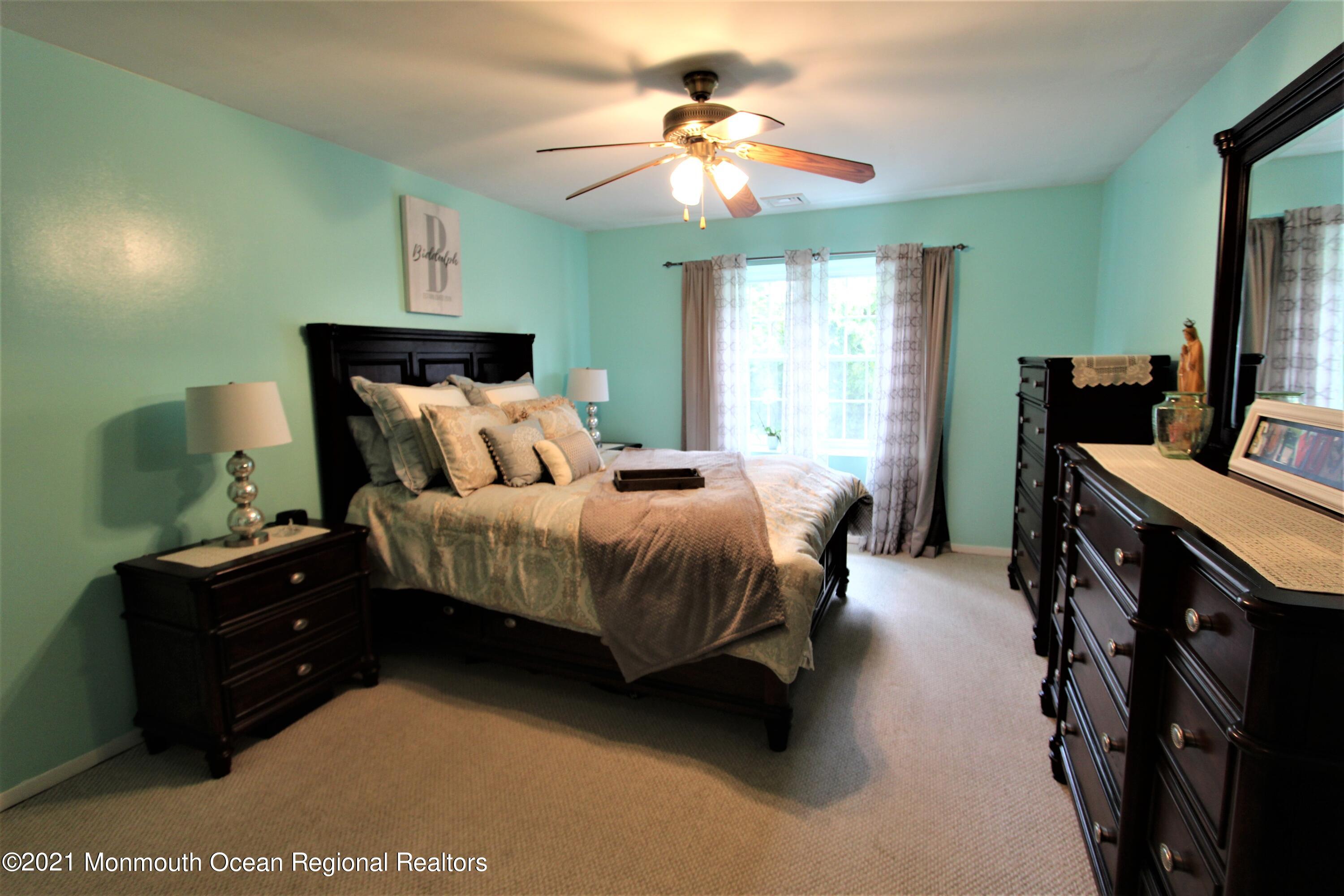 231 Atlantic Street, Unit 48 Keyport, NJ 07735 - Photo 21 of 32 a bedroom with a bed and a chandelier