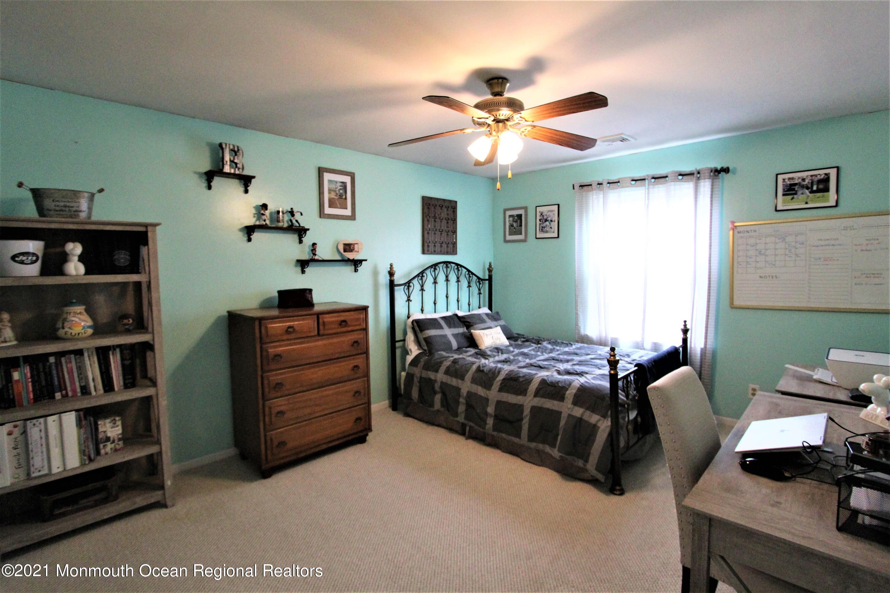 231 Atlantic Street, Unit 48 Keyport, NJ 07735 - Photo 25 of 32 a bedroom with a bed and a chandelier