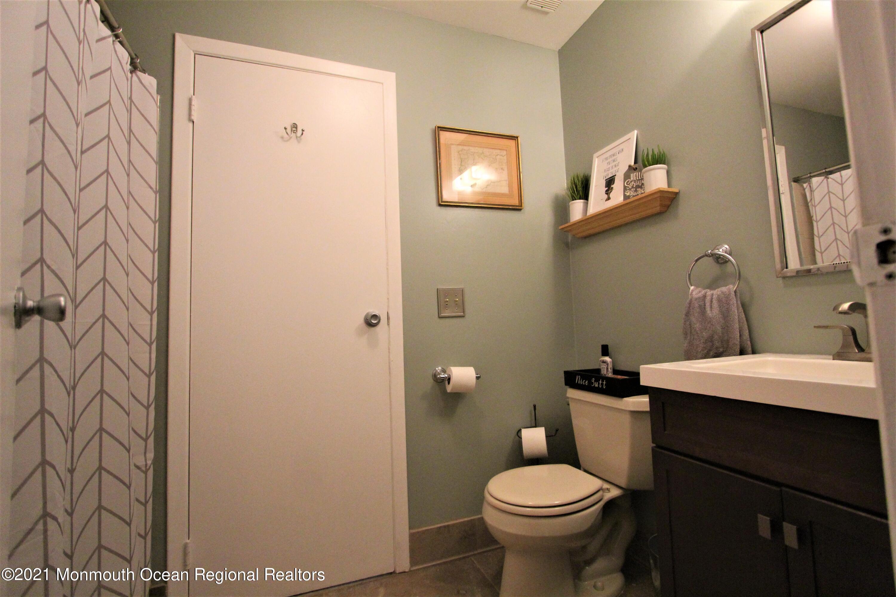 231 Atlantic Street, Unit 48 Keyport, NJ 07735 - Photo 31 of 32 a bathroom with a toilet sink and mirror
