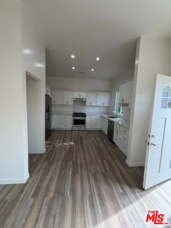 a kitchen with granite countertop white cabinets and white appliances