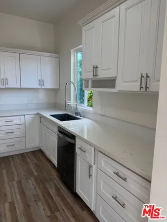 a kitchen with granite countertop a stove and cabinets