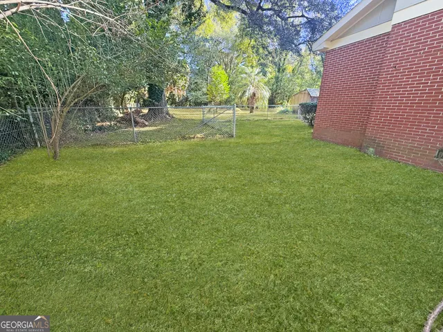 a view of a backyard with large trees