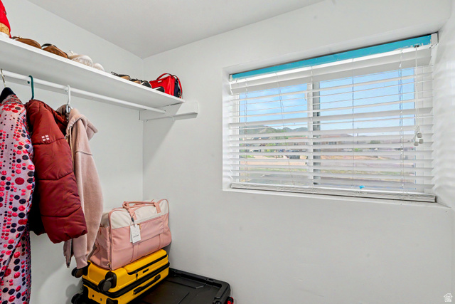 3689 Lasso Loop Circle Magna, UT 84044 - Photo 10 of 26 Coat Closet space featuring a window with white horizontal blinds, a white wall-mounted shelf, and a white hanging rod