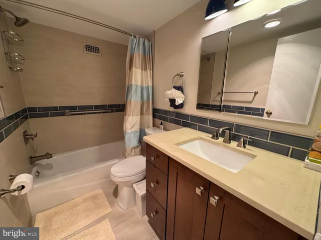 a bathroom with a sink a toilet a mirror and shower