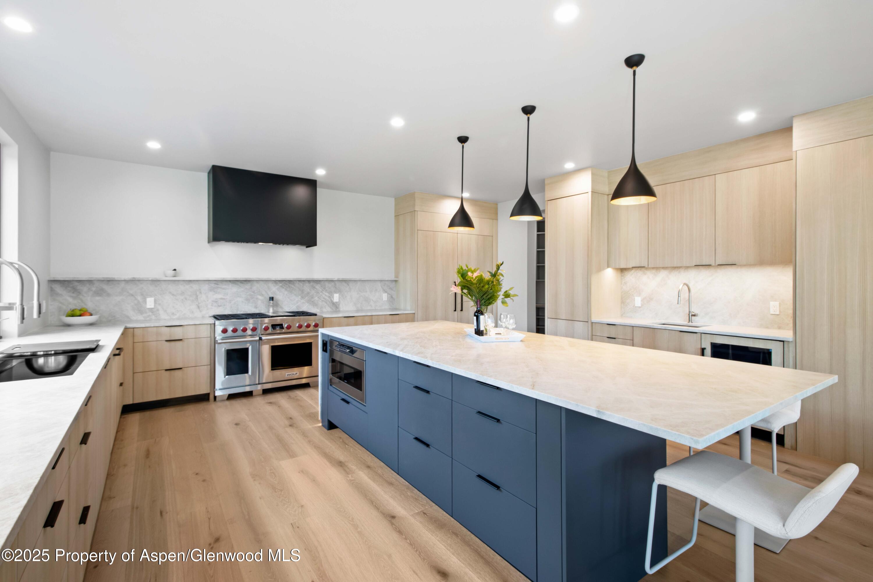 719 Perry Ridge Carbondale, CO 81623 - Photo 57 of 68 a large kitchen with stainless steel appliances kitchen island granite countertop a sink a stove and a wooden floors