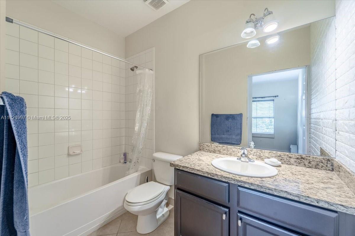370 Lake Monterey Circle Boynton Beach, FL 33426 - Photo 5 of 17 a bathroom with a granite countertop sink a toilet a mirror and shower