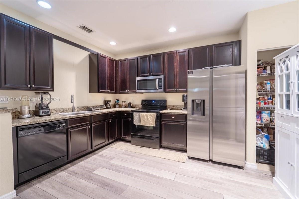 370 Lake Monterey Circle Boynton Beach, FL 33426 - Photo 8 of 17 a kitchen with stainless steel appliances granite countertop a refrigerator stove a sink and dishwasher