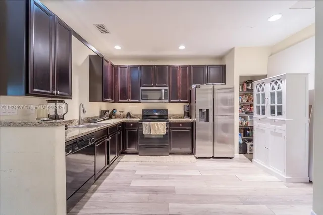 a kitchen with stainless steel appliances granite countertop a refrigerator stove and oven