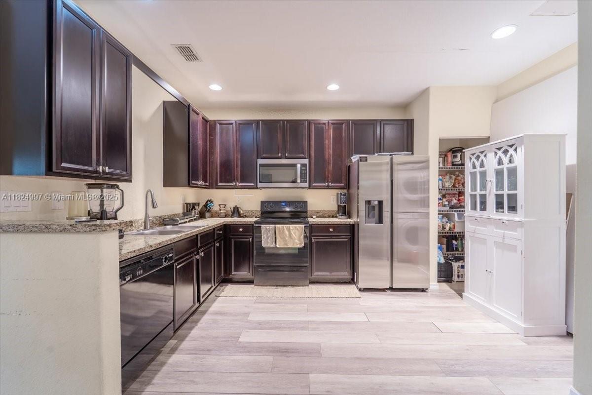 370 Lake Monterey Circle Boynton Beach, FL 33426 - Photo 9 of 17 a kitchen with stainless steel appliances granite countertop a refrigerator stove and oven