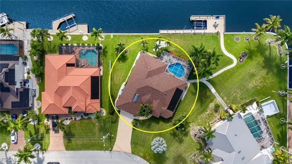 an aerial view of a house with a yard and swimming pool