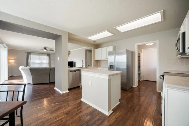 a kitchen with white cabinets and stainless steel appliances