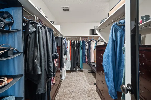 a view of walk in closet with clothes