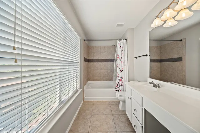 a bathroom with a tub a sink and a large mirror