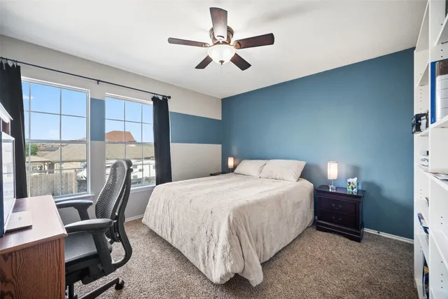 a bedroom with a bed a flat screen tv and a large window