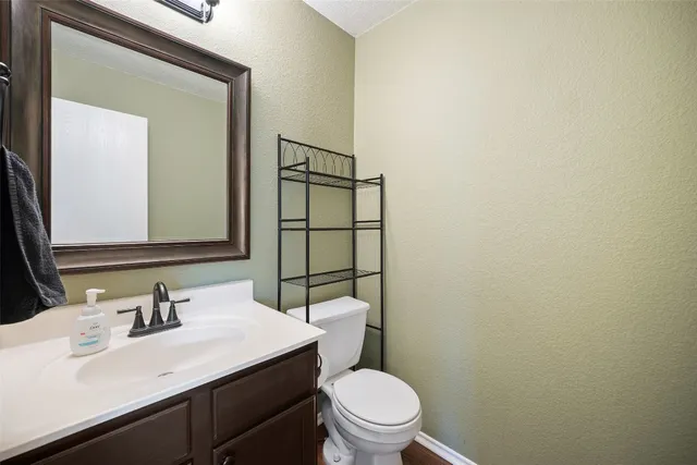 a bathroom with a sink vanity mirror and toilet