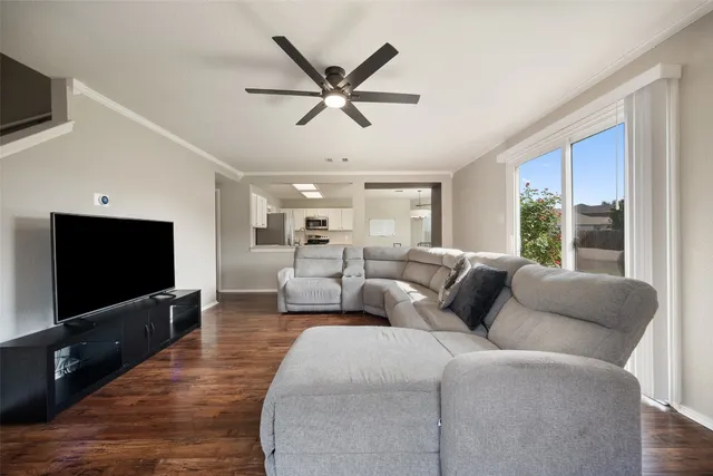 a living room with furniture a flat screen tv and a large window