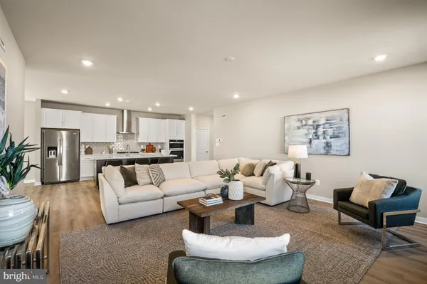 a living room with furniture and a view of kitchen