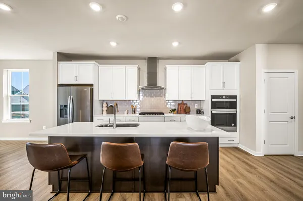 a kitchen with granite countertop white cabinets and stainless steel appliances