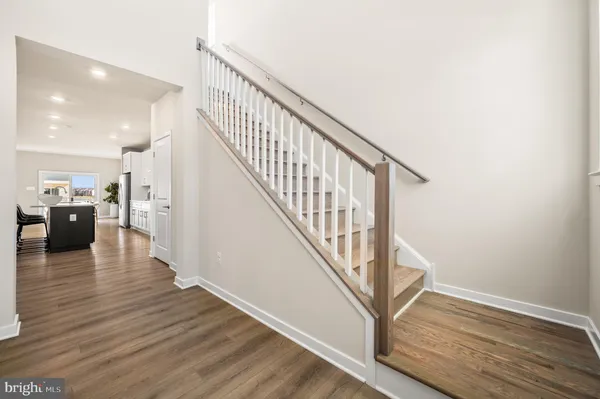 a view of a hallway with wooden floor and staircase